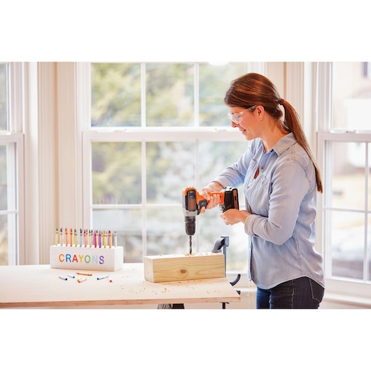 BLACKDECKER BCD70250PK cordless drill in use on wood, indoor workspace with crayons display.