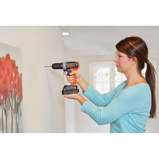 Photo of BLACKDECKER cordless drill BCD702C1 in use drilling into wall indoors.