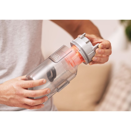 BLACK+DECKER BHFEA18D1 vacuum dust container with orange filter, being held and opened by hands.
