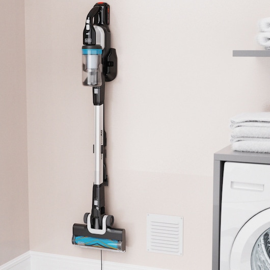BLACKDECKER BHFEB520D1 cordless stick vacuum cleaner mounted on a wall in a laundry room.