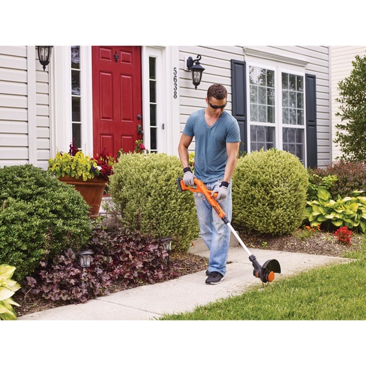 20 volt MAX lithium 10 inch string trimmer edger being used by a person to trim grass, with new look powerconnect batery