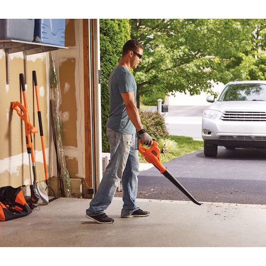 20 Volt Lithium Sweeper being used by a person in a garden.