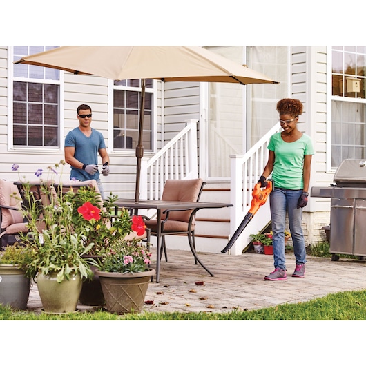 20 Volt Lithium Sweeper being used by a person in a garden.
